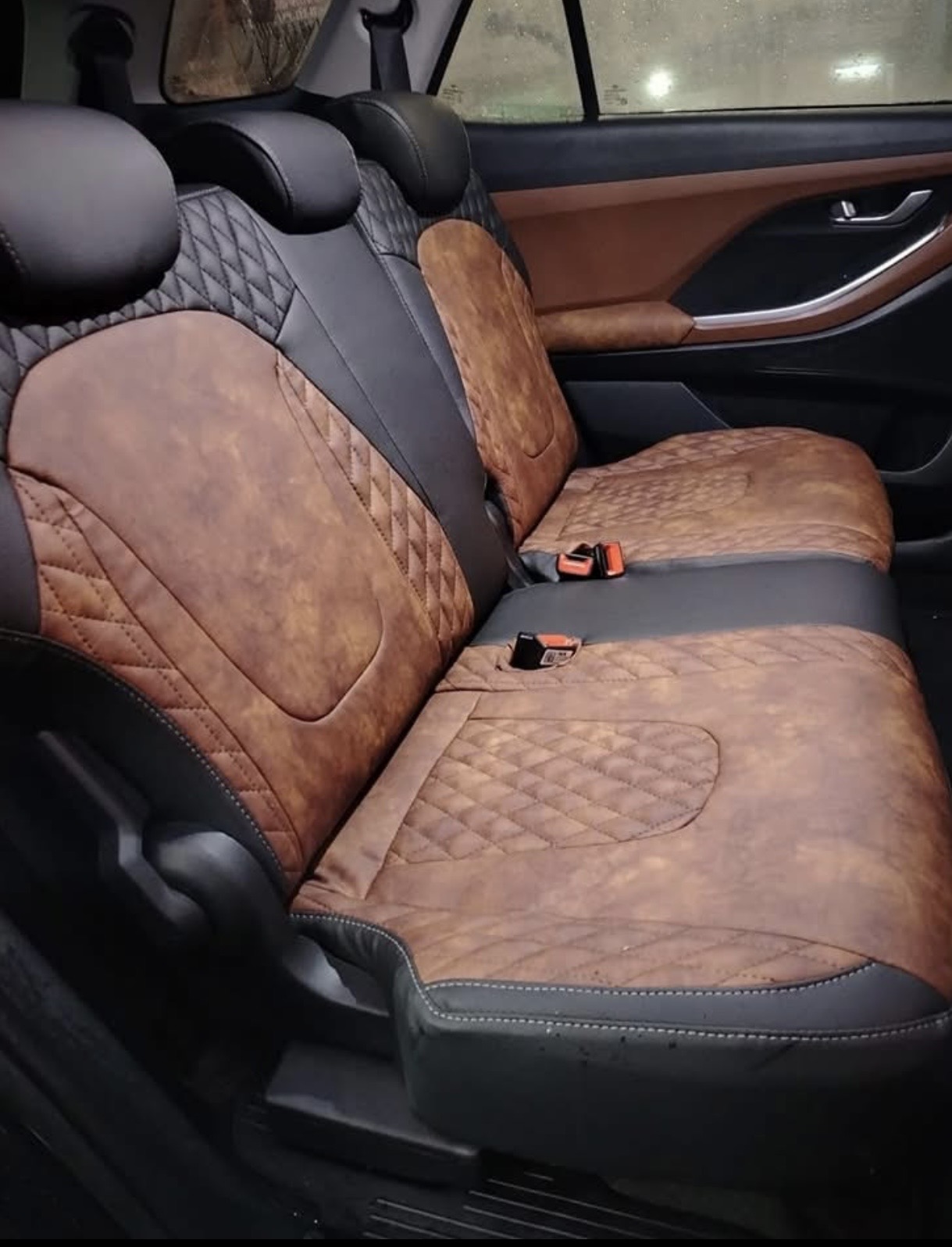 Asientos traseros de coche tapizados en piel marrón camel con capitoné y combinación negra