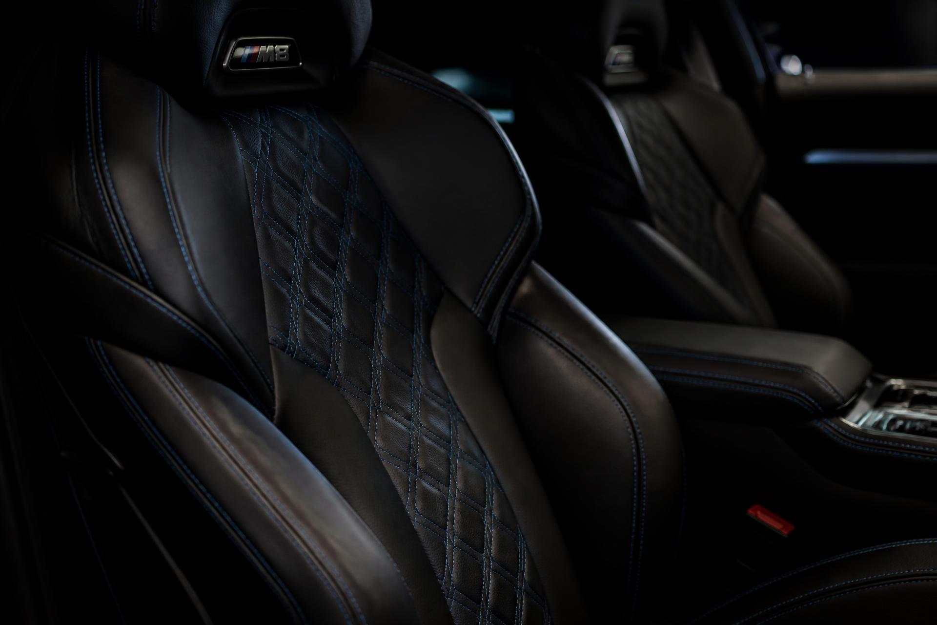Interior de coche con asiento tapizado en piel negra y costura azul a contraste